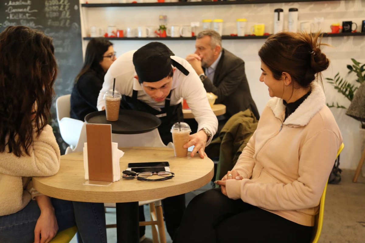 An employee serves coffee at Agonist, a coffee shop that hires people with special needs, in Zalka, Lebanon, February 26, 2018. Thomson Reuters Foundation/Heba Kanso