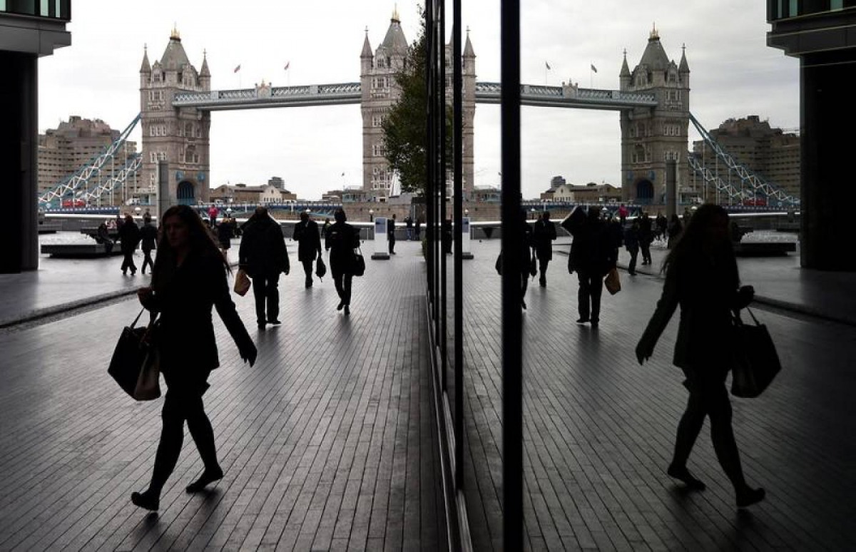 Workers walk through the More London business district with Tower Bridge seen behind in London, November 11, 2015. Reuters/Toby Melville
