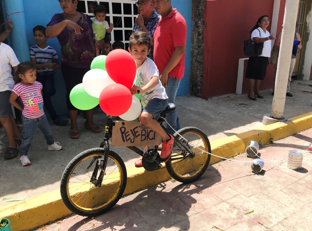 A child rides a bike adorned with balloons in Tepetitan, Mexico, July 1, 2018. Reuters/Anthony Esposito