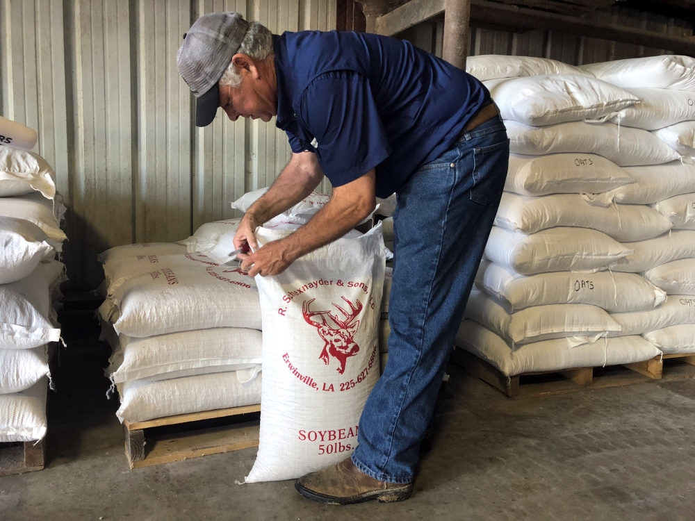 Soybean farmer Raymond Schexnayder Jr closes a bag of soybeans from his farm outside Baton Rouge in Erwinville, Louisiana, July 9, 2018. Reuters/ Aleksandra Michalska