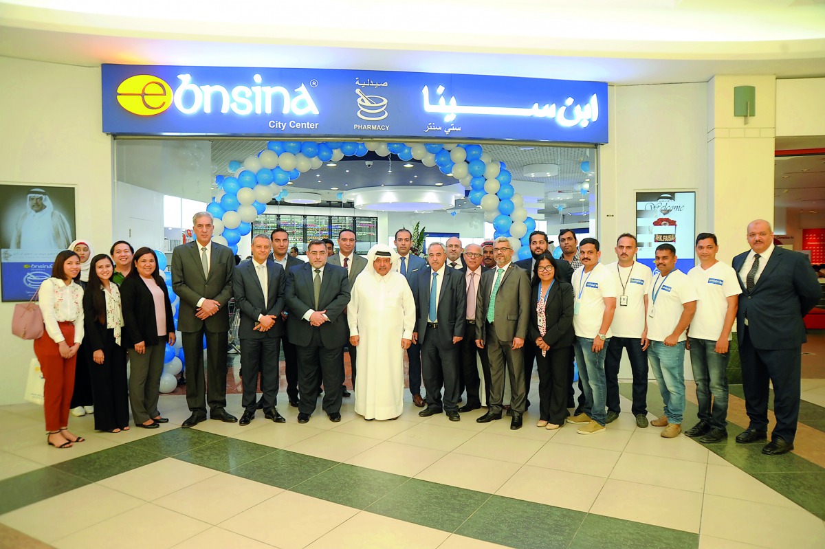Sheikh Faisal bin Qassim Al Thani (centre), Chairman of Aamal Company, posing for a group picture with the employees at the reopening of its pharmacy at the City Center Mall after its complete renovation.