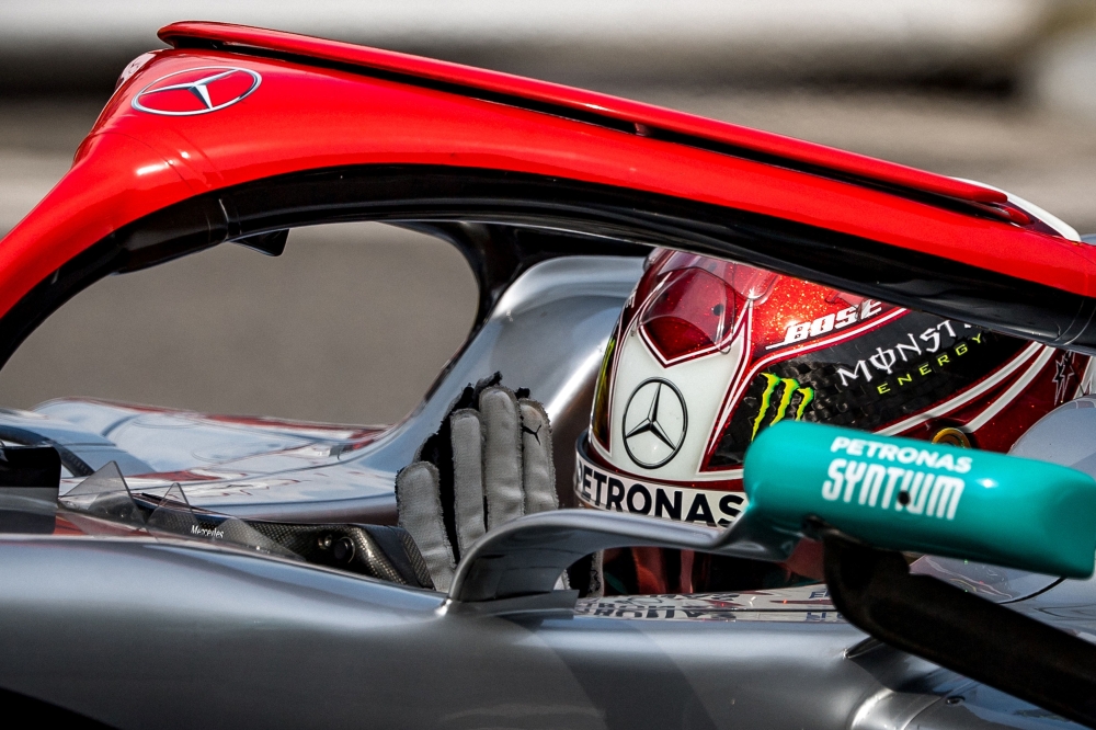 First placed Mercedes' British driver Lewis Hamilton reacts in his car with a red halo in tribute to late F1 legend Niki Lauda after winning the pole position during the qualifying session at the Monaco street circuit on May 25, 2019 in Monaco, ahead of t