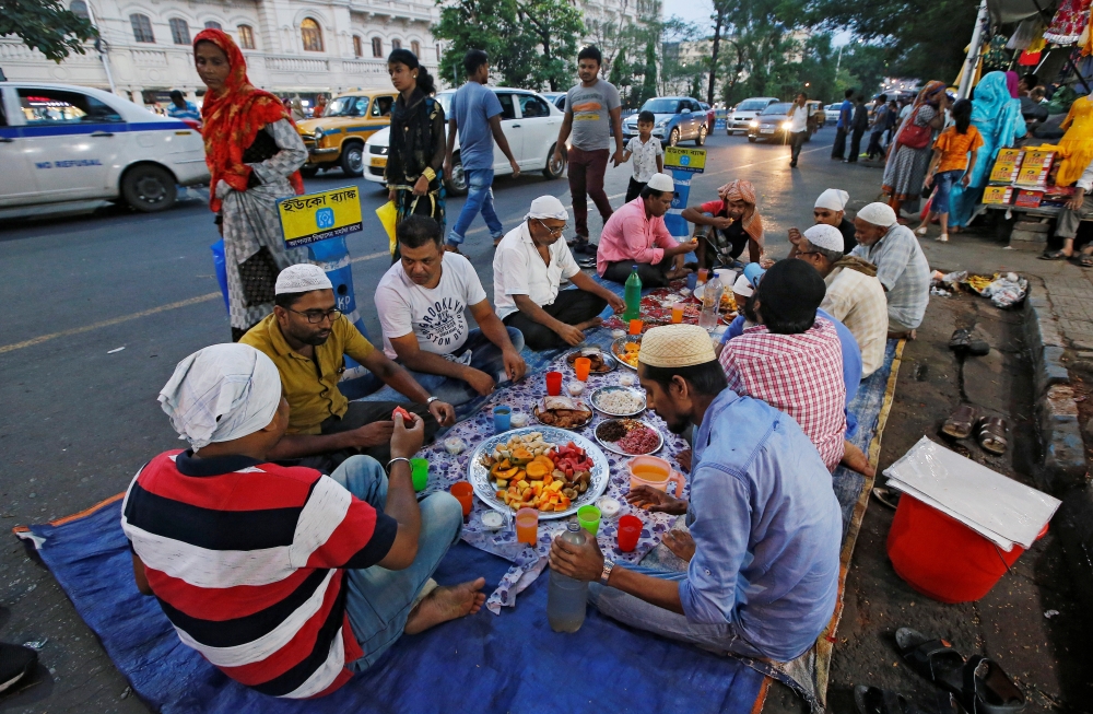 Vendors eat their iftar meals in front of their garment shops on a roadside in Kolkata, India May 28, 2019. Reuters/Rupak De Chowdhuri