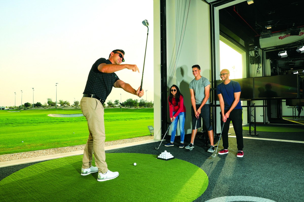 A professional golfer offers tips to student golfers at the Centre of Excellence at the Education City Golf Club.