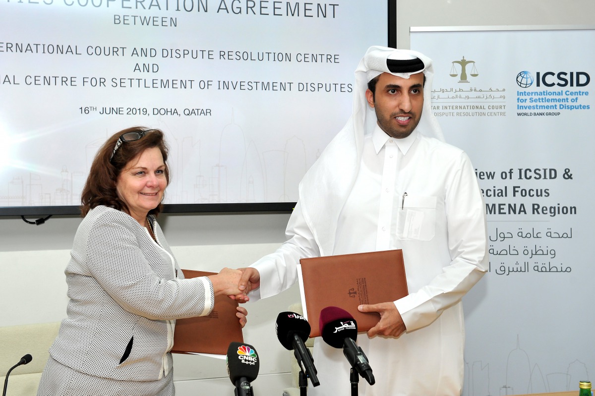 Faisal Rashid Al Sahouti (right), CEO, Qatar International Court and Dispute Resolution Centre (QICDRC); and Meg Kinnear, Secretary General, International Centre for Settlement of Investment Disputes (ICSID), exchanging documents after they signed an agre