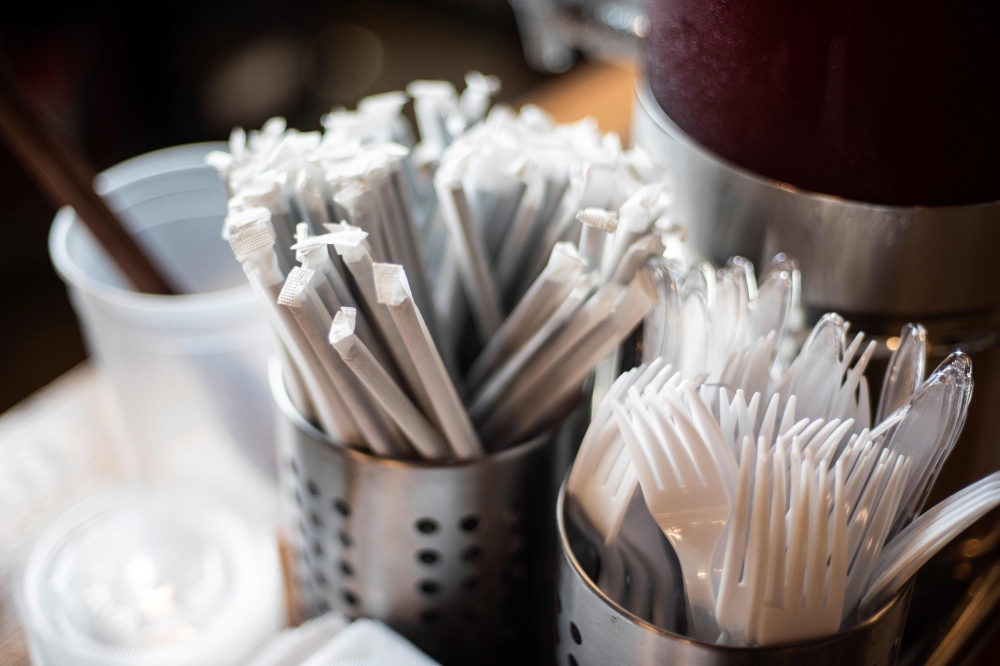 Plastic straws wrapped in paper and plastic forks are seen at a food hall in Washington DC on June 20, 2019. AFP / Eric Baradat 