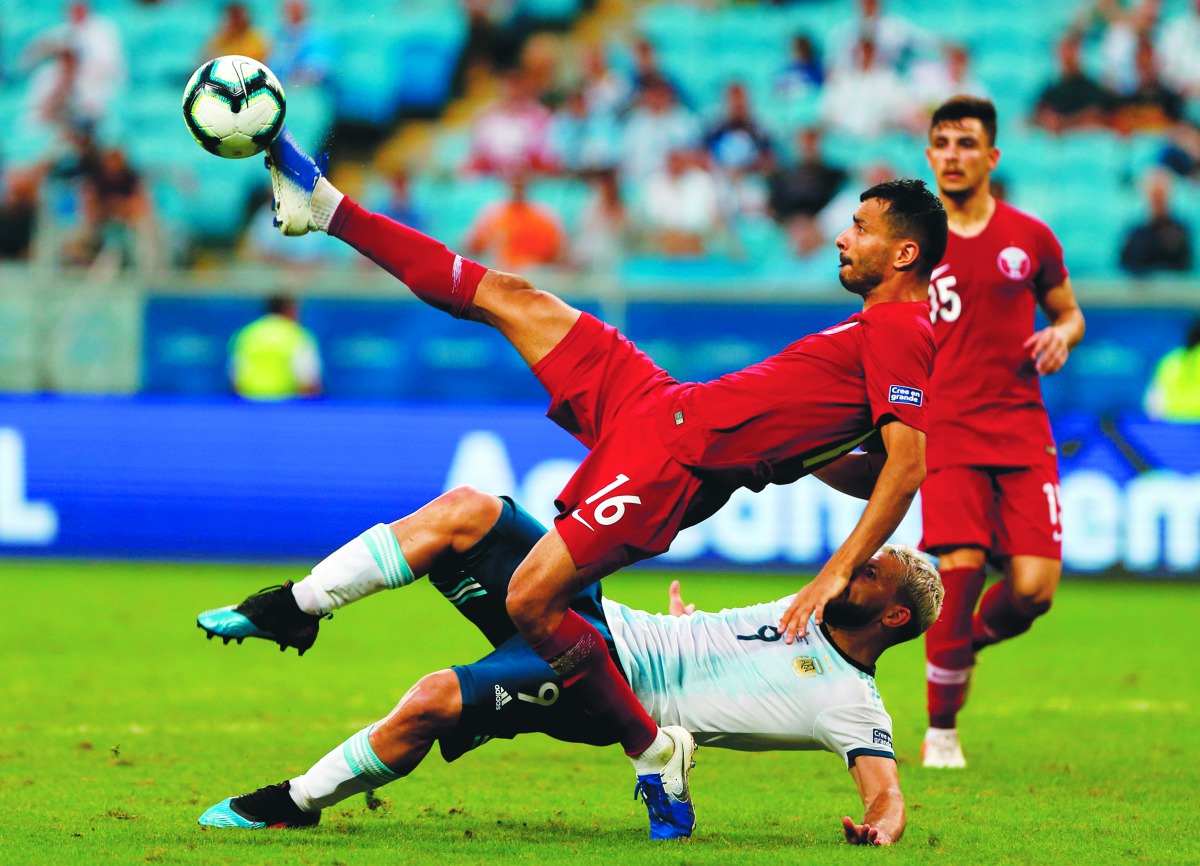 Qatar’s Boualem Khoukhi and Argentina’s Sergio Aguero struggle for the ball during the Copa America tournament group match at the Gremio Arena in Porto Alegre, Brazil, on Sunday.