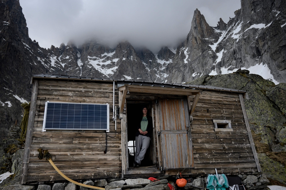 Sarah Cartier, guardian of the Charpoua refuge on the Charpoua Glacier, poses on the threshold of the refuge in Chamonix-Mont-Blanc on June 19, 2019. AFP / Marco Bertorello 