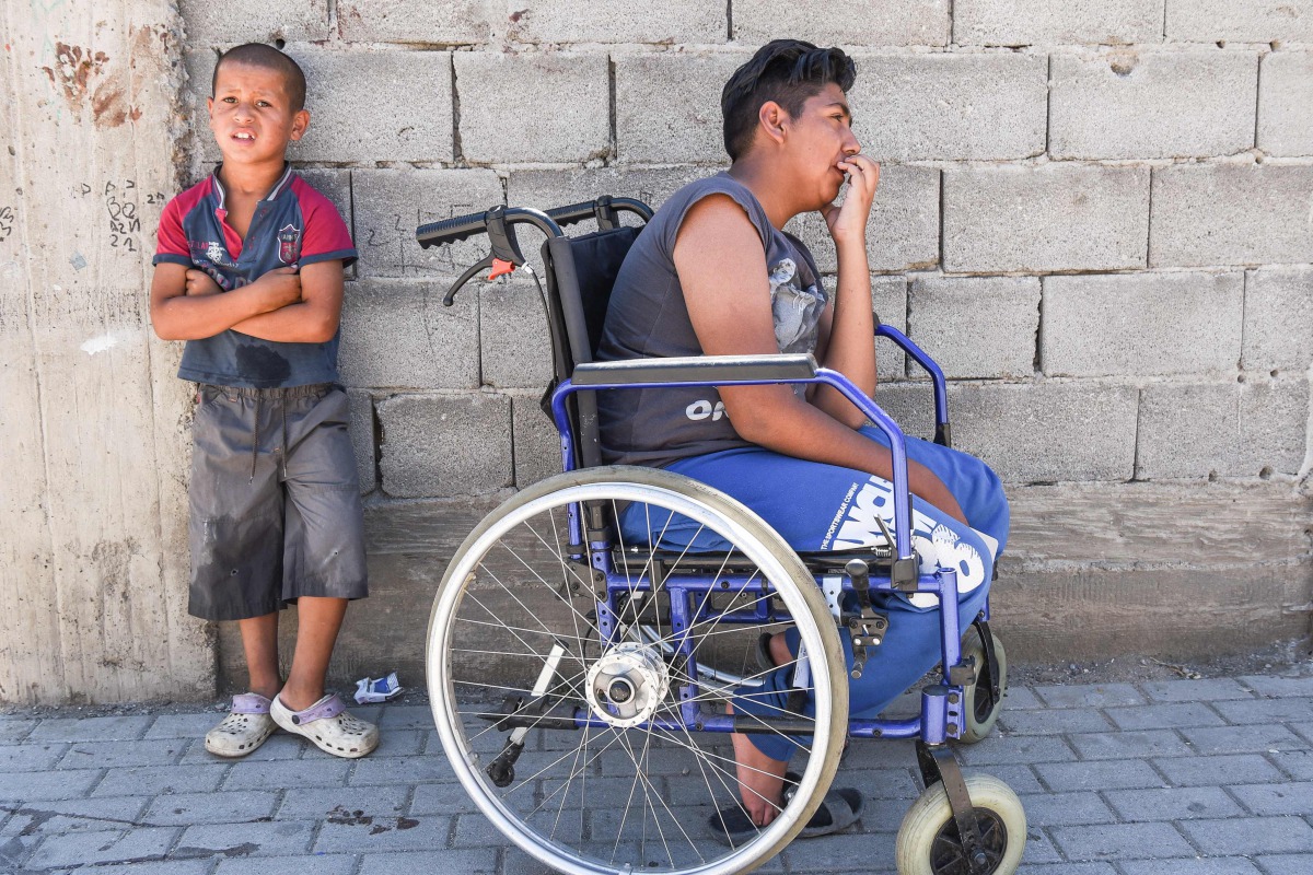 A scene in which one Jetullah Veliu, a 16-years-old, sitting on a wheelchair along a street in the Roma neighborhood in the town of Mitrovica on July 7, 2017. AFP/Armend Nimani