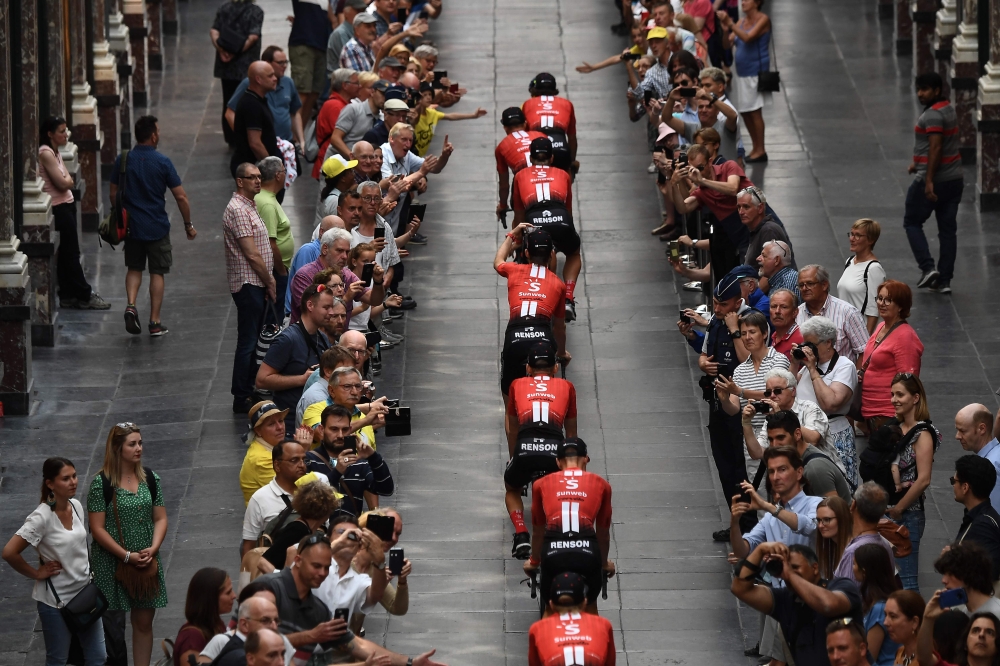 Germany's Team Sunweb cycling team rides through the Saint-Hubert Royal Galleries on their way to the team presentation ceremony in Brussels on July 4, 2019, two days prior to the start of the 106th edition of the Tour de France cycling race.  AFP / Anne-