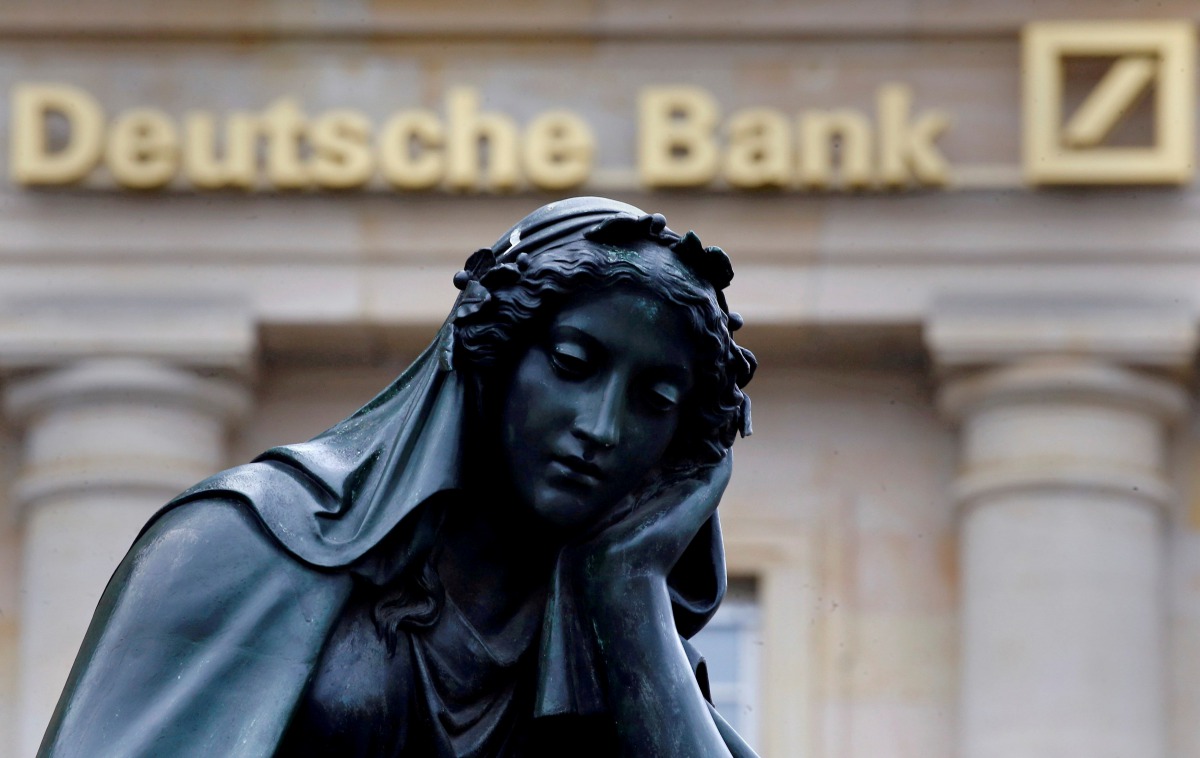 A statue is seen next to the logo of Germanys Deutsche Bank in Frankfurt, January 26, 2016. Reuters/Kai Pfaffenbach