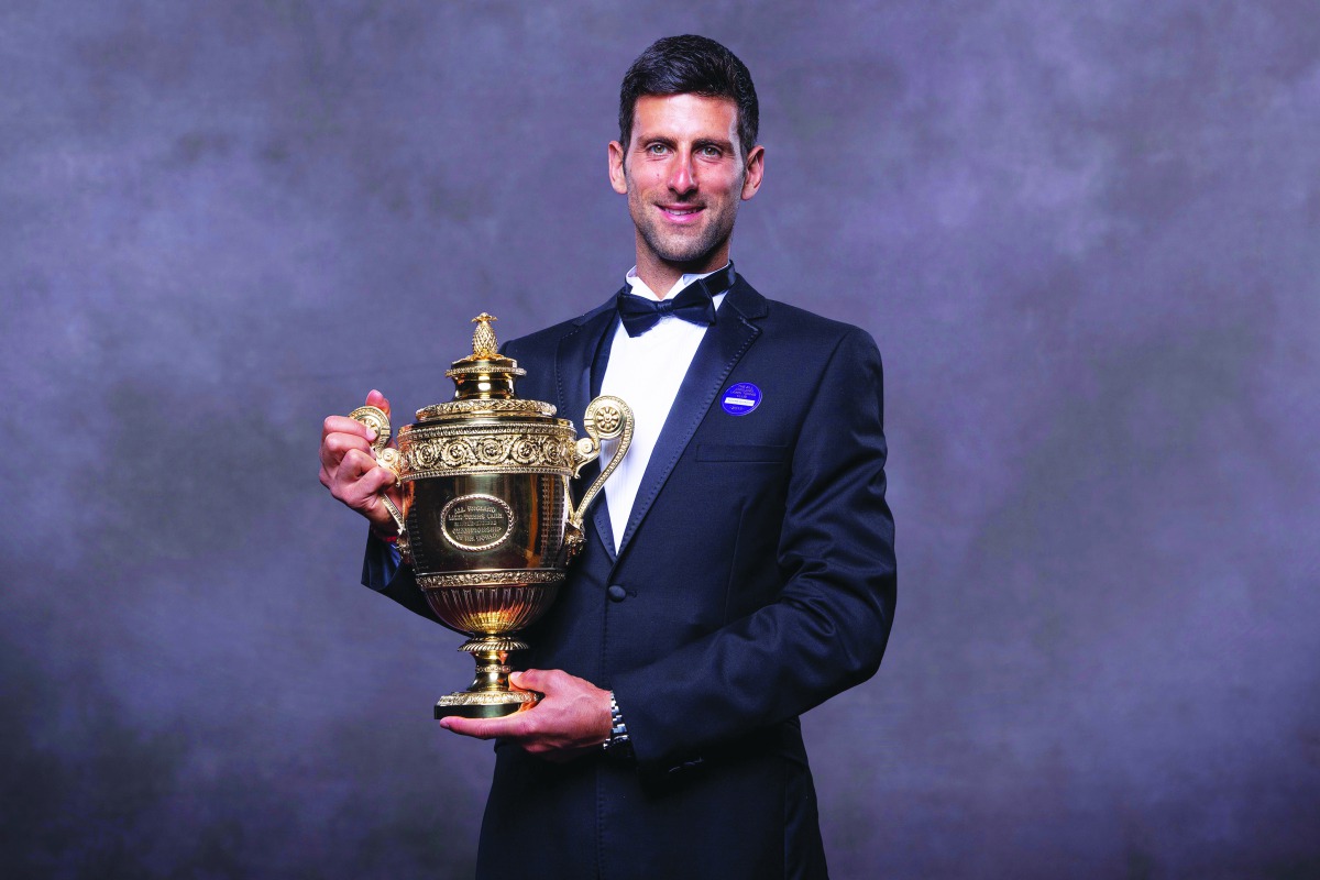 A handout picture released by the All England Lawn Tennis and Croquet Club on July 15, 2019, shows 2019 Wimbledon Men's singles champion Serbia's Novak Djokovic posing for a photograph with his trophy at the Champions Dinner on July 14, 2019 in central Lo