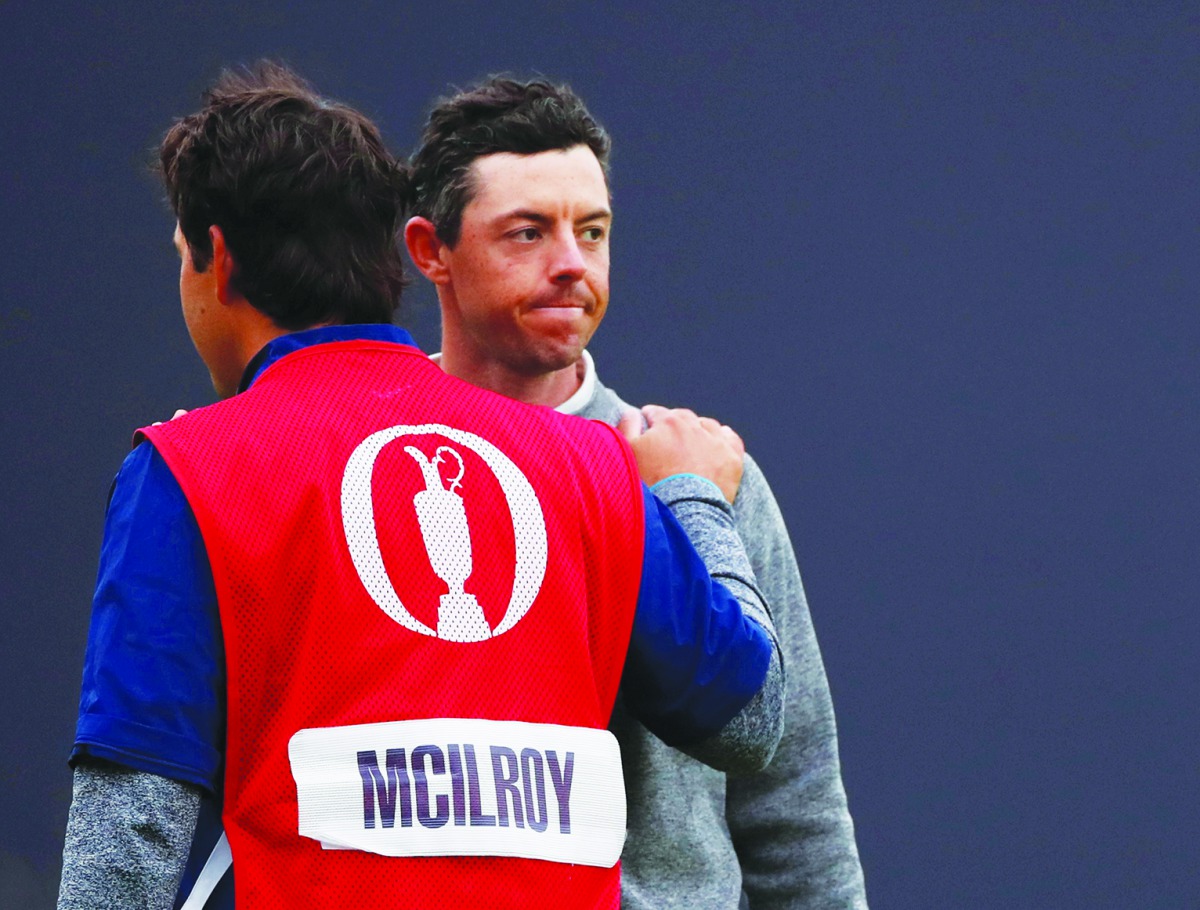 Northern Ireland's Rory McIlroy looks dejected with his caddie after not making the cut.  Reuters/Paul Childs