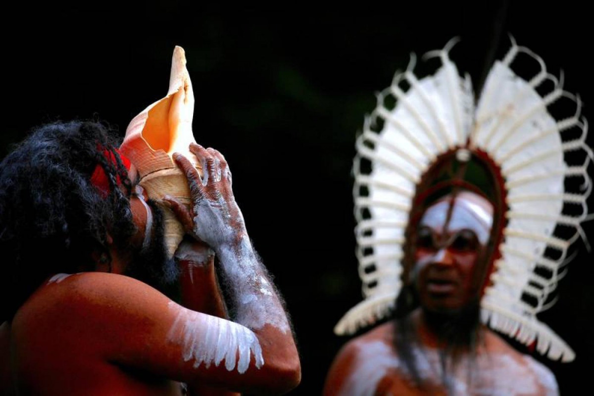 An Australian Aboriginal man blows into a shell during a welcoming ceremony at Government House in Sydney, Australia, June 28, 2017. Reuters/David Gray