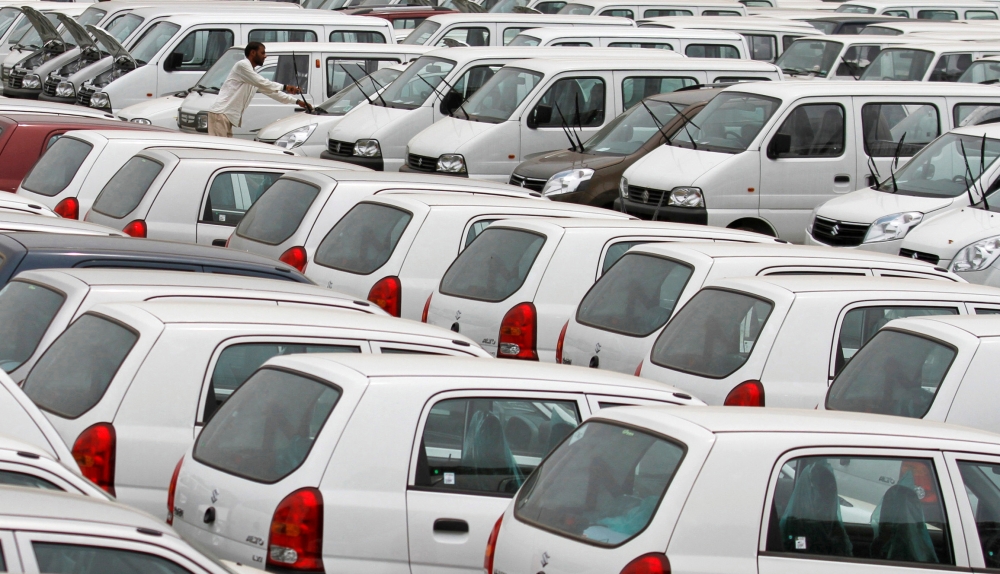 A worker adjusts the windscreen wipers of a parked car at a Maruti Suzuki stockyard on the outskirts of the western Indian city of Ahmedabad. (REUTERS/Amit Dave/File Photo)