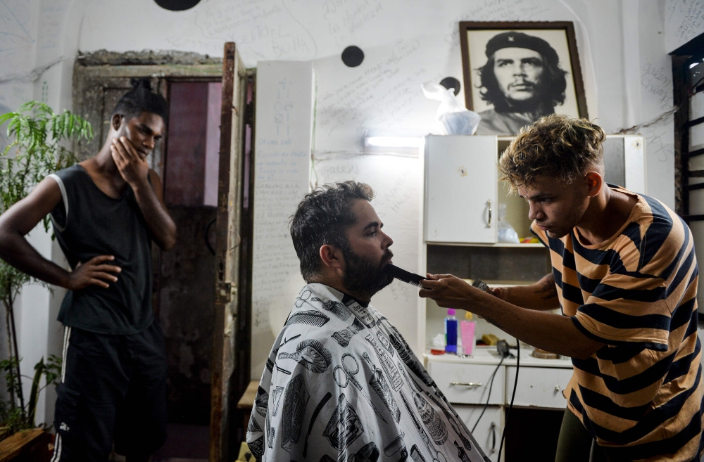 A barber cuts a client beard in a barbershop of Havana, on August 7, 2019.  AFP / Yamil Lage
 

