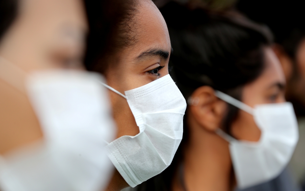 People wear masks while gathering ahead a demonstration to demand more protection for the Amazon rainforest, in Rio de Janeiro, Brazil August 25, 2019. Reuters/Sergio Moraes