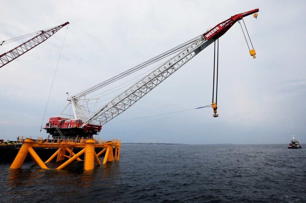 A crane hangs over the first jacket installed to support a turbine for a wind farm in the waters of the Atlantic Ocean off Block Island, Rhode Island, July 27, 2015. Reuters / Brian Snyder