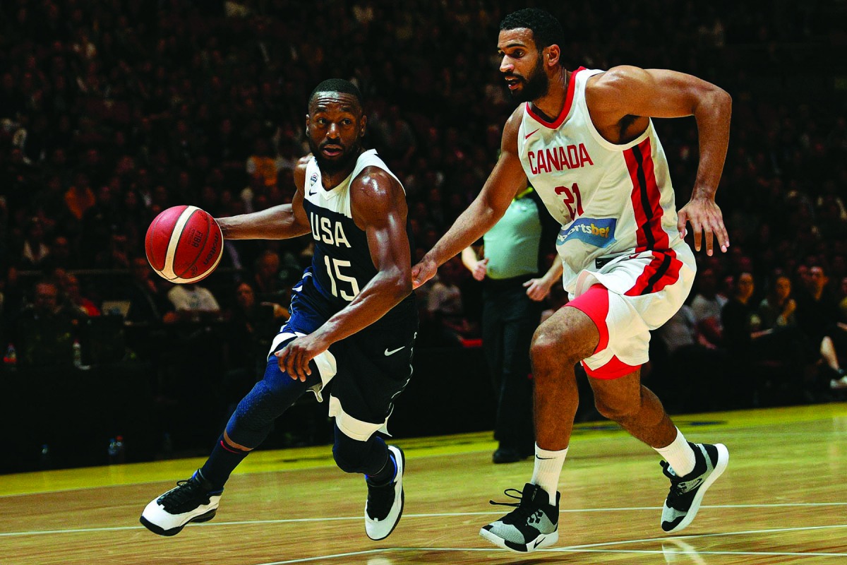 Kemba Walker of the US dribbles past Canada's Thomas Scrubb (R) during their friendly basketball match in Sydney on August 26, 2019. AFP / Saeed Khan 