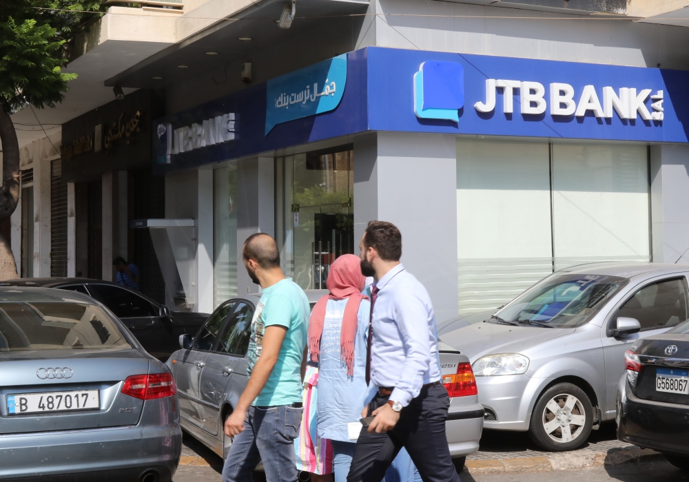 People walk past a branch of Jammal Trust Bank in the Beirut's Hamra street on August 30, 2019, in the Lebanese capital. AFP / Anwar Amro 