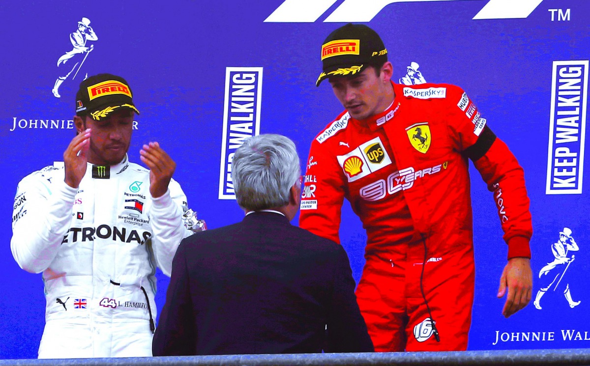 Charles Leclerc (R) of Ferrari celebrates after winning the 2019 F1 Belgium Grand Prix at the Spa-Francorchamps circuit in Spa, Belgium on September 01, 2019. Hamilton (L) of Mercedes took second place as Valtteri Bottas (not seen) of Mercedes have finish