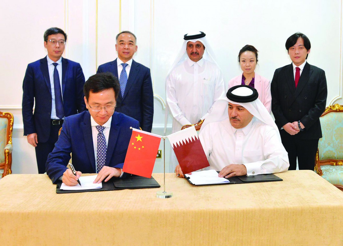 Qatar Chamber Chairman Sheikh Khalifa bin Jassim Al Thani (standing, centre) and Fan Ruiping (second left), the head of the visiting Chinese delegation, witnessing the signing of a cooperation agreement between Taleb Group and Chengdu Hi-tech Zone at QC h