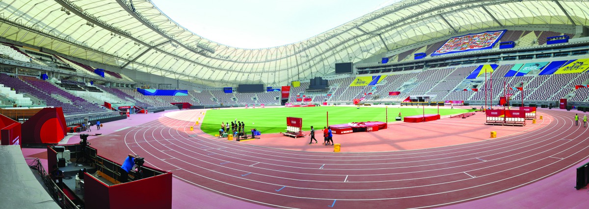 Technical staff members work on final arrangements at the Khalifa International Stadium, the main venue for the IAAF World Championships Doha 2019, yesterday. Pictures: Abdul Basit / The Peninsula
