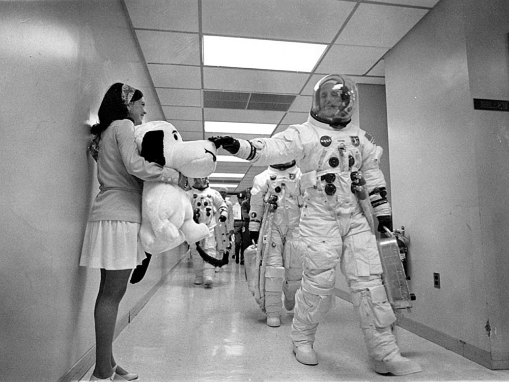 Apollo 10 Commander Tom Stafford, heading to the Kennedy Space Center launch pad, pats the nose of a stuffed Snoopy held by Jamye Flowers, the secretary of astronaut Gordon Cooper, May 18, 1969. NASA/AFP