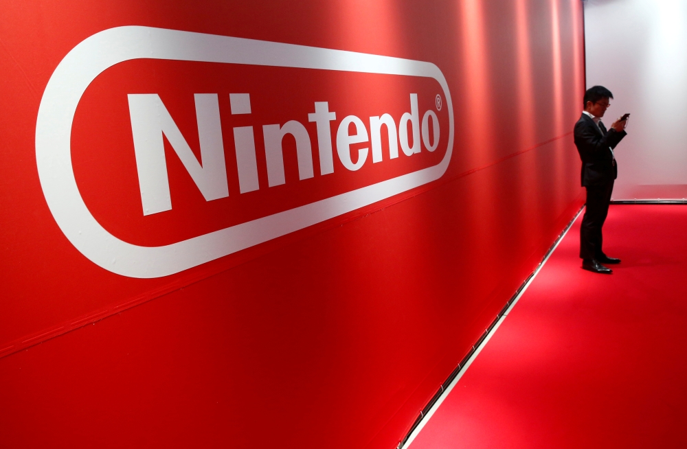 FILE PHOTO: A man stands in front of Nintendo's logo at the presentation ceremony of its new game console Switch in Tokyo, Japan, Jan. 13, 2017. REUTERS/Kim Kyung-Hoon/File Photo