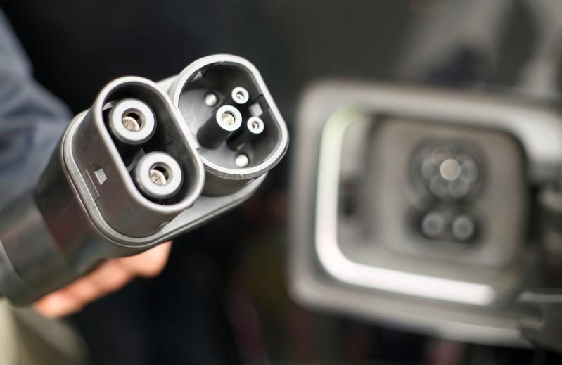 A man holds DC-power charging plug of his BMW i3 electric car during the presentation of a new super-fast multi-charging power column comfort charge belonging to Deutsche Telekom. (Reuters file/  Wolfgang Rattay) 