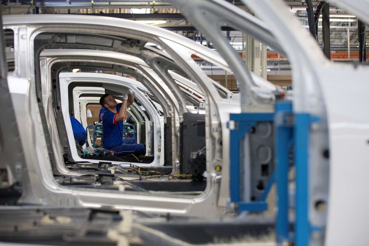 An employee works on the automobile assembly line of Bluecar electric city cars at Renault car maker factory in Dieppe, western France, September 1, 2015. Reuters / Philippe Wojazer