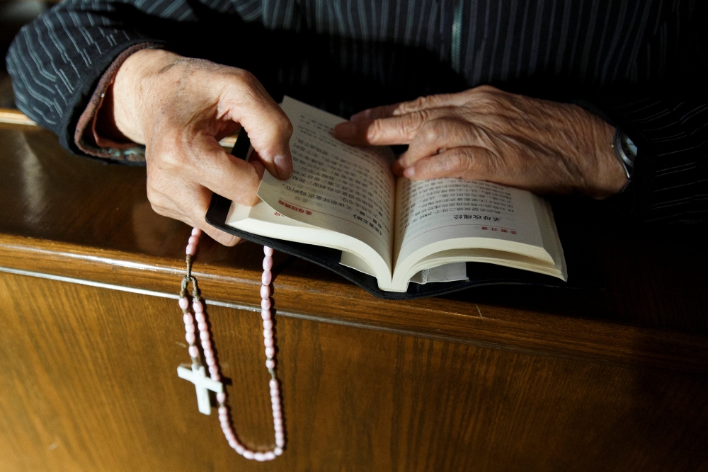 Representative image: A believer reads the bible during mass at St Josephs Church, a government-sanctioned Catholic church, in Beijing, China, October 1, 2018. Reuters / Thomas Peter