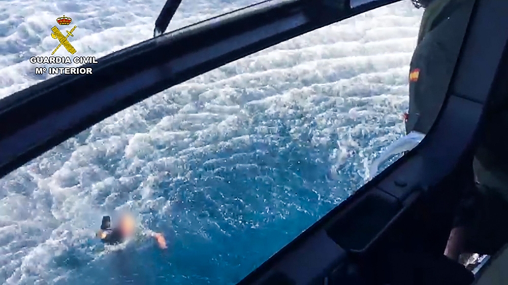 A police officer swimming back to the police helicopter, after three Spanish police officers who were thrown into the sea when their boat crashed during a high-speed chase, off the coast of Mijas, Malaga, southern Spain on October 4, 2019.  AFP/ Spanish G