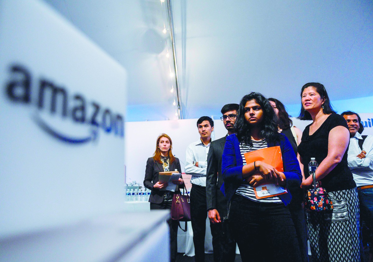 Job hunters wait to speak with Amazon recruiters at an Amazon Career Day event, where recruiters help candidates build interview skills, prepare them for job interviews and give them more information on the roles within the company, at Crystal City in Arl