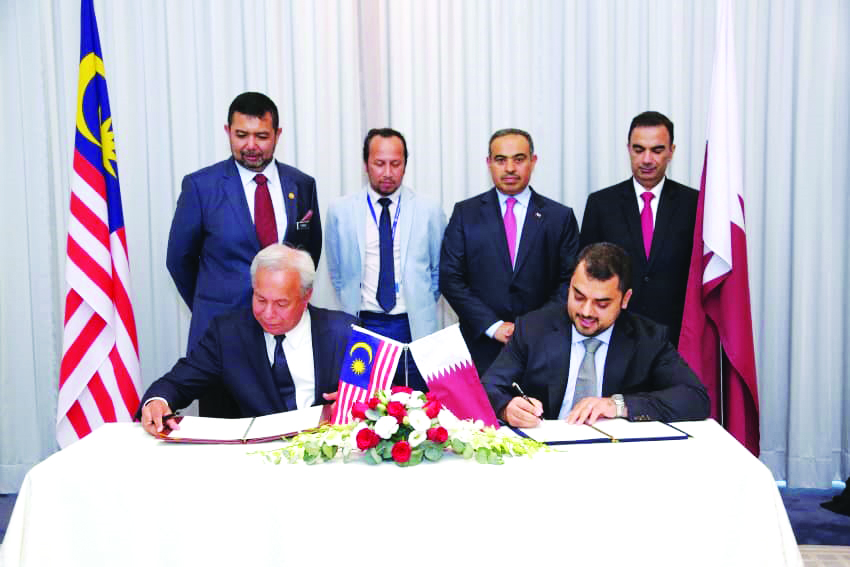 H E Ali bin Ahmed Al Kuwari (standing second right), Minister of Commerce and Industry, and other officials during the signing ceremony in Kuala Lumpur, Malaysia.