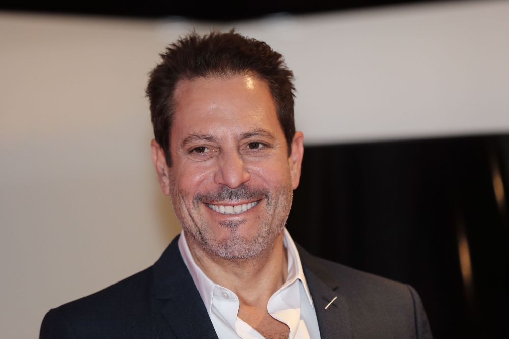 US producer, director, and writer of film Darren Star poses with his 'Cannes series Award' trophy for his career in the television and cinema at the MIPCOM, the World's biggest television, and entertainment market, on October 14, 2019 in Cannes, southeast
