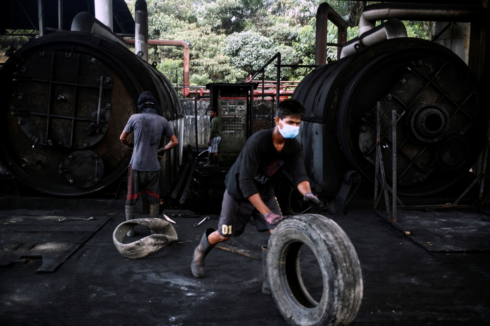 Workers operate furnaces at a tyre pyrolysis plant in Kulai, Johor, Malaysia August 7, 2019. Picture taken August 7, 2019. Reuters/Edgar Su
 