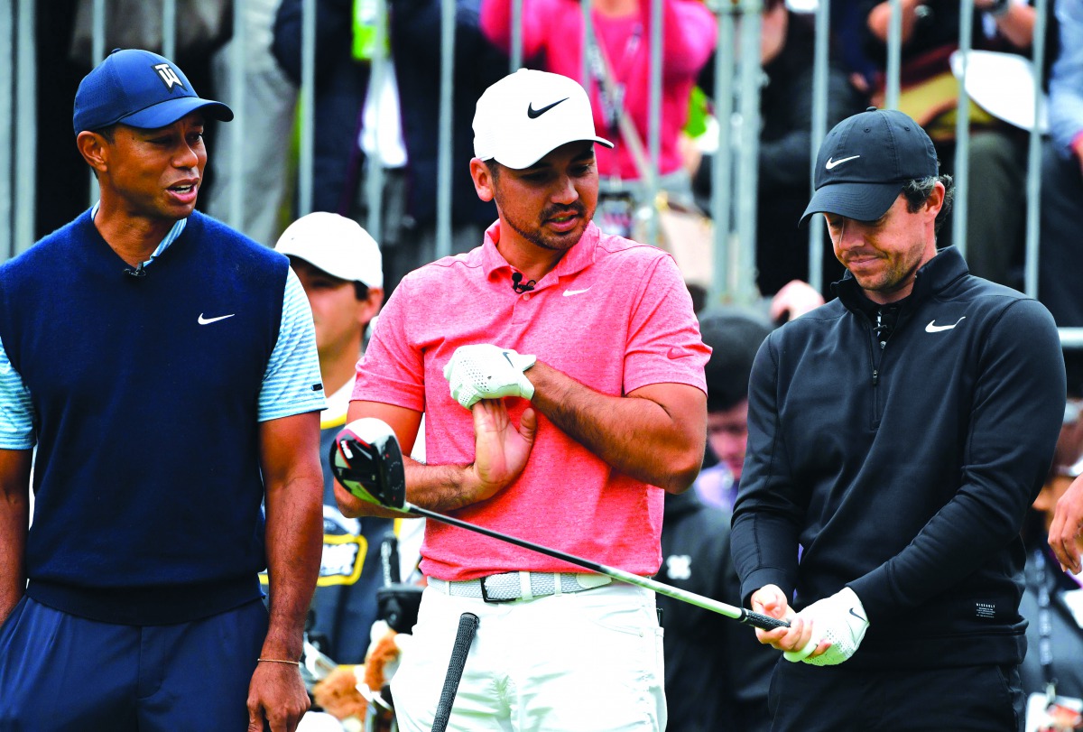 Tiger Woods of the US (L), Jason Day of Australia (C) and Rory McIlroy of Northern Ireland (R) chat at the first hole tee at a 