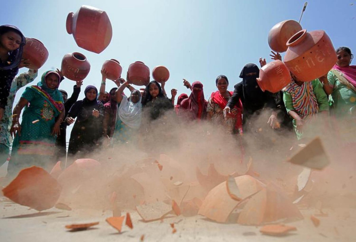  Women throw earthen pitchers onto the ground in protest against a shortage of drinking water outside the municipal corporation office in Ahmedabad, India, May 16, 2019. Reuters/Amit Dave 