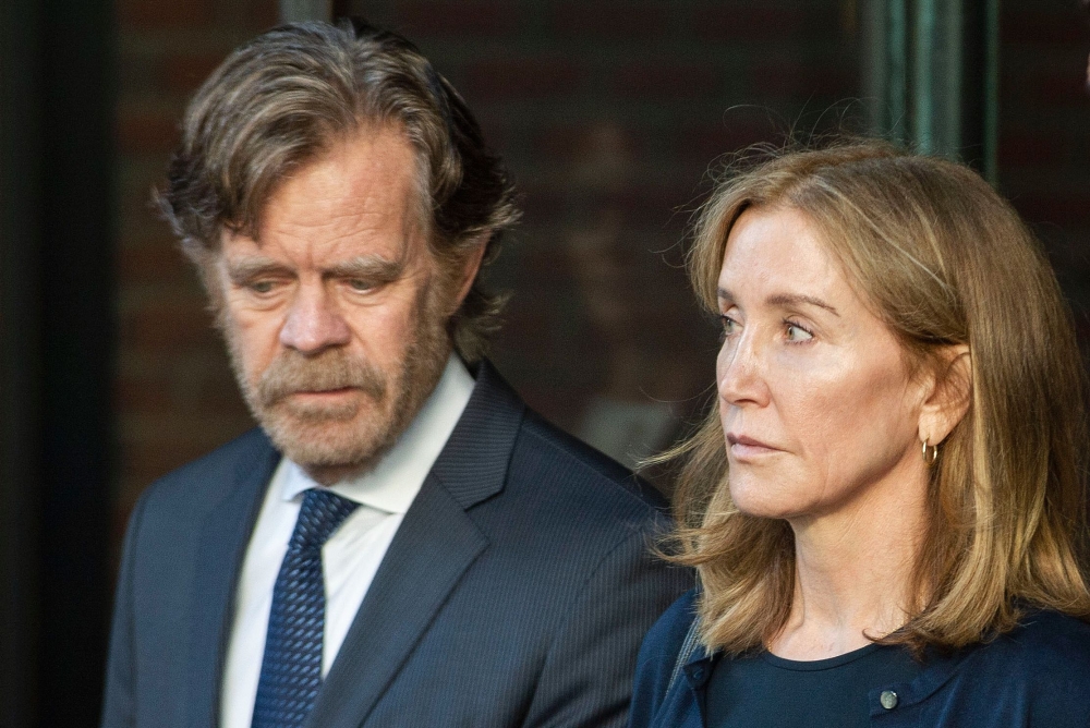 In this file photo taken on September 13, 2019, actress Felicity Huffman, escorted by her husband actor William H. Macy, exits the John Joseph Moakley United States Courthouse in Boston, where she was sentenced by Judge Talwani for her role in the College