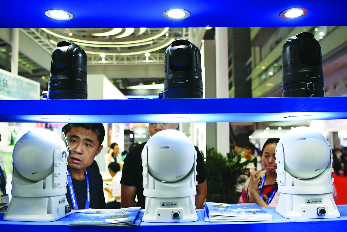 A visitor looks at surveillance cameras at the 17th China Public Security Expo at the Shenzhen Convention and Exhibition Center on October 28, 2019. AFP / Noel Celis