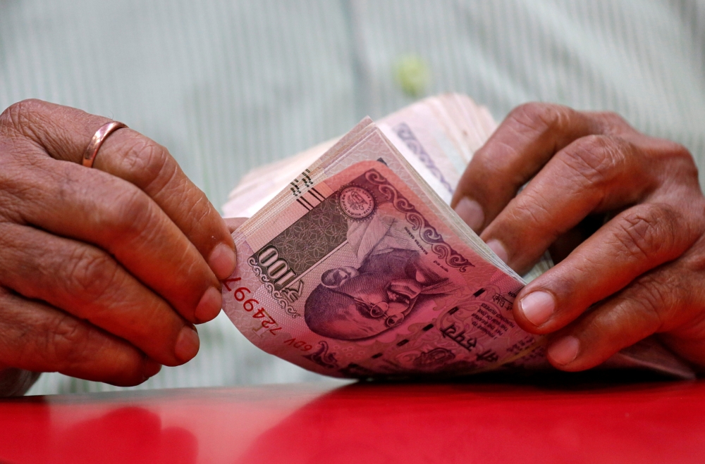A man counts Indian currency notes inside a shop in Mumbai, August 13, 2018. Reuters / Francis Mascarenhas