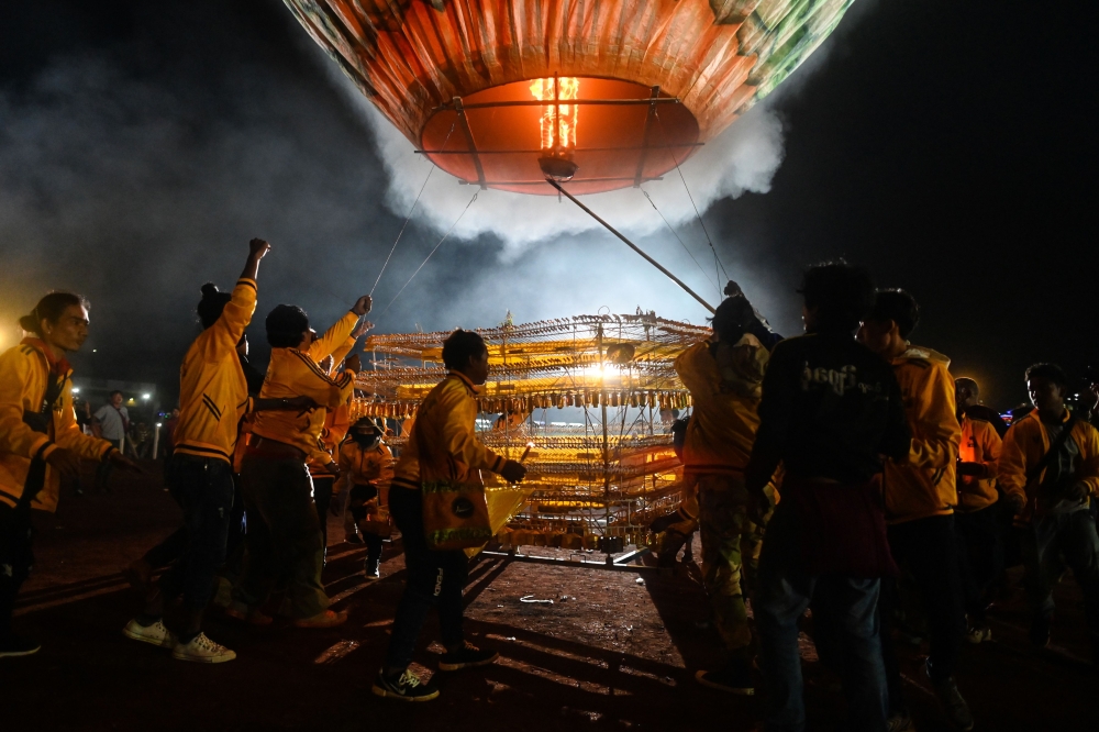 This picture taken on November 4, 2019 shows participants releasing a hot-air balloon attached with fireworks during the Tazaungdaing Lighting Festival at Taunggyi in Myanmar's northeastern Shan State. AFP / Ye Aung Thu
 