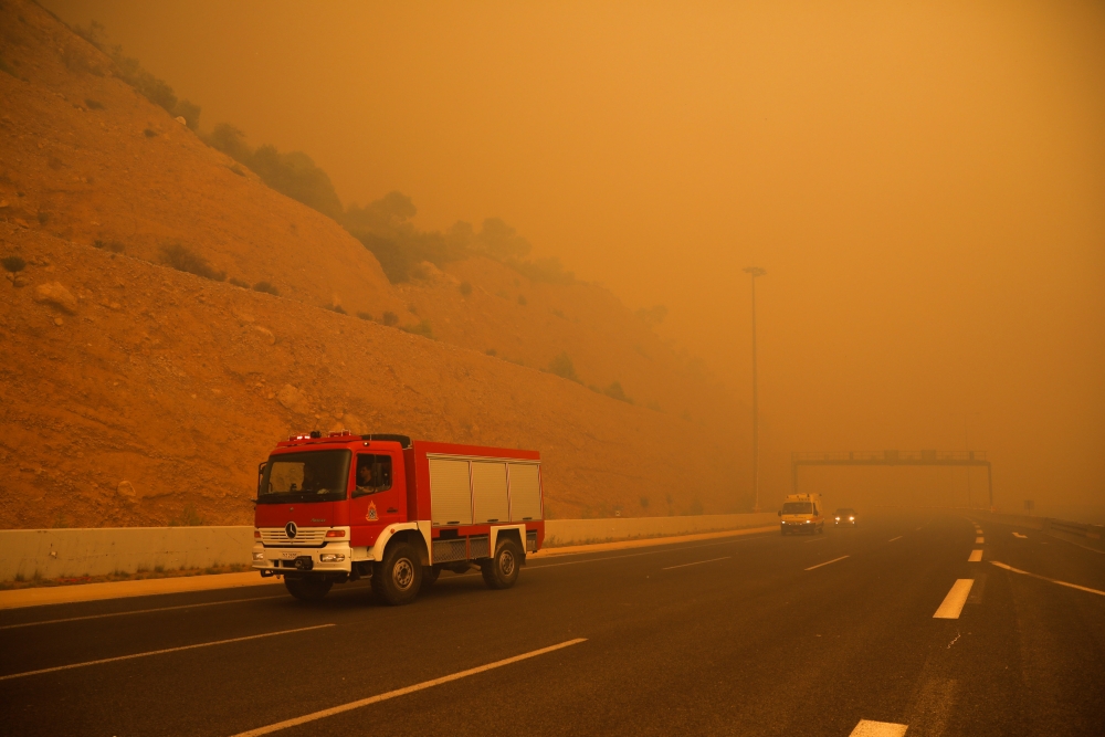 Fire fighters are seen amid smoke as a wildfire burns in Kineta near Athens, July 23, 2018. Reuters / Alkis Konstantinidis