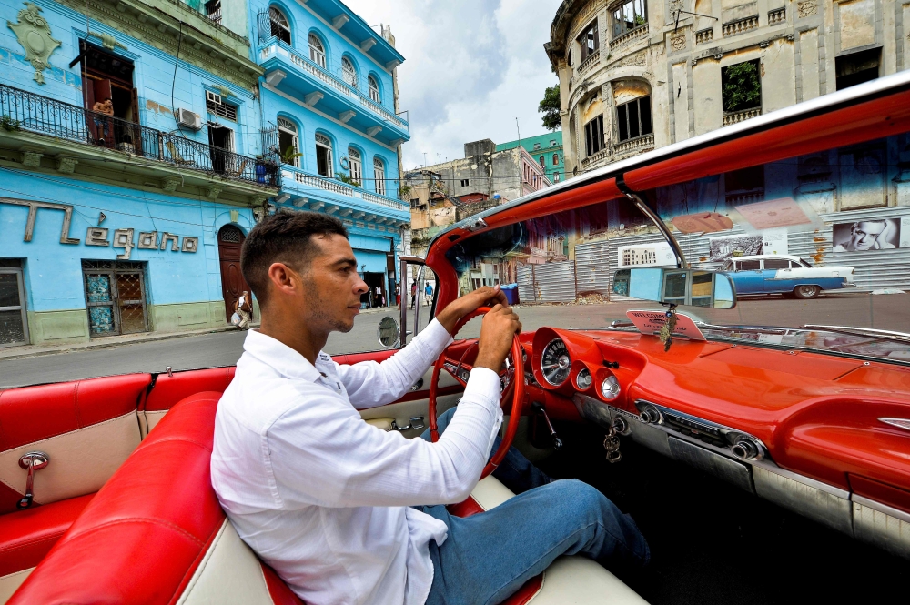 Cuban Yosbel Sosa, 33, drives his Chevrolet Impala '59 through the streets of Havana, on August 20, 2019, in search of tourists.  AFP / Yamil Lage 