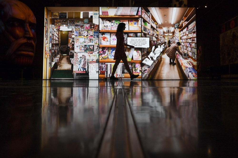 A museum employe walks past a large photograph of a manga store in Japan during a press preview for the exhibition Manga at the British Museum in London on May 22, 2019. AFP / Daniel Leal-Olivas