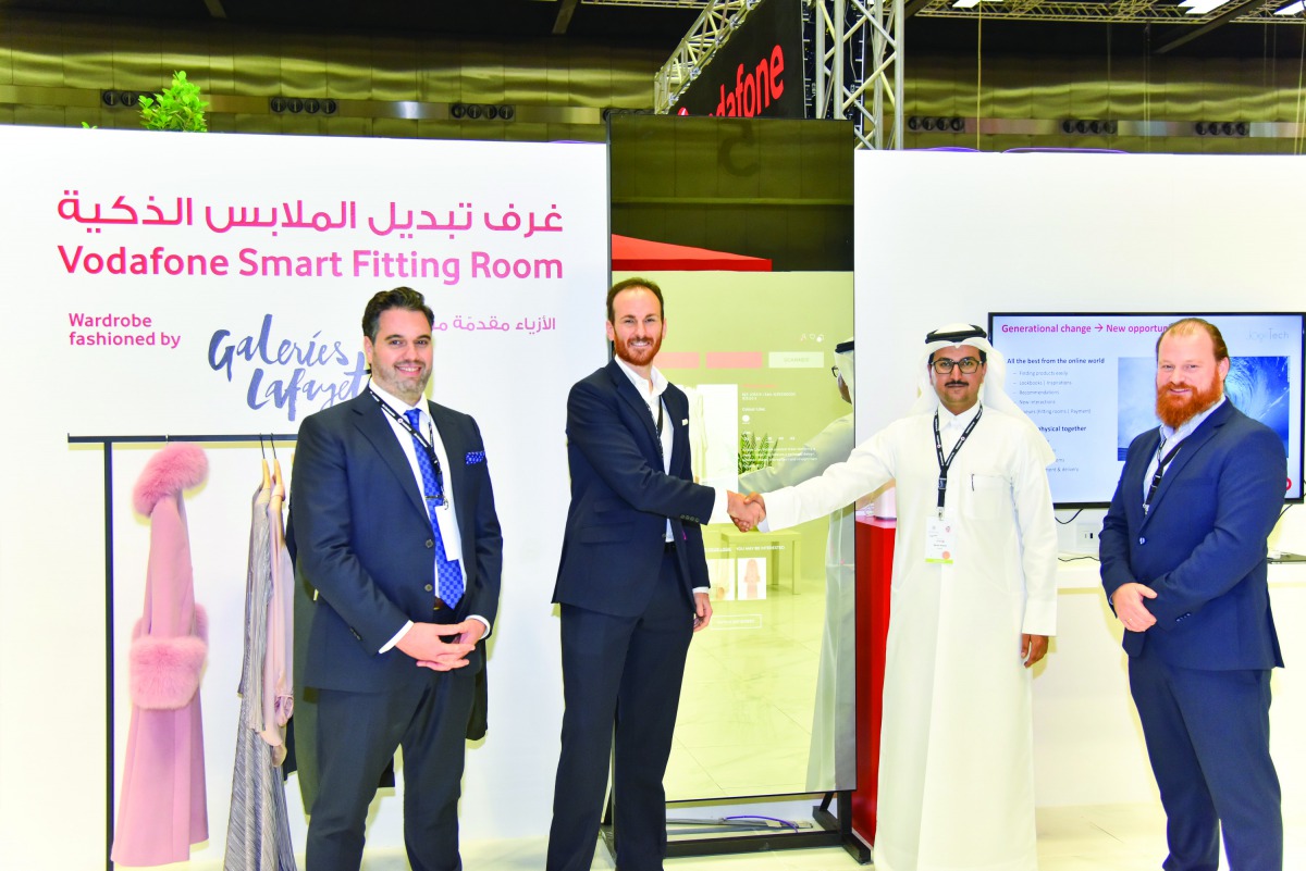 Mahday Saad Al Hebabi (second right) and Gonzalo Martin shaking hands in front of digital fitting room. 