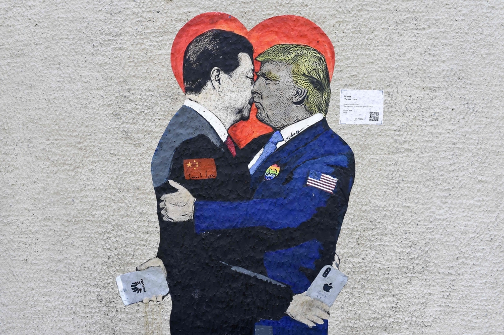 FILE PHOTO: ‘Smart Love’ by Italien street artist TvBoy depicts Xi Jinping holding an i-Phone smartphone kissing US President Donald Trump holding an Huawei smartphone in Milan on June 29, 2019. AFP / Miguel Medina