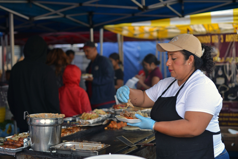 A cook prepares tacos at a street vending stand in the Pinata District in Downtown, Los Angeles, on March 23, 2019. AFP / Agustin Paullier