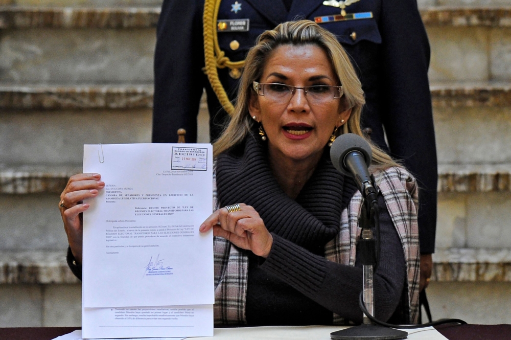 Bolivian interim President Jeanine Anez shows a document as she presents a bill on the Transition Electoral Regime for the 2020 general elections at Quemado presidential palace in La Paz on November 20, 2019. AFP / Jorge Bernal 